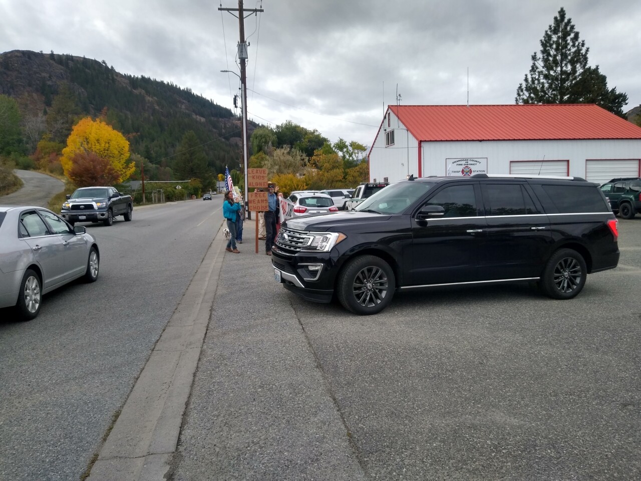 Inslee's SUV leaves FD6 Twisp Station in front of protesters. Photo by C. Creighton.